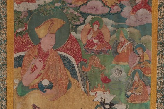 Tibet MSS 62, Box 41. Painting detail showing a large figure draped in yellow, red, and orange robes with a halo. To the right are four seated divine figures of a much smaller scale on a green ground. 