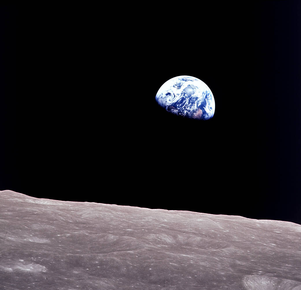Image of the Earth, partially shrouded in darkness, as seen from the Moon's orbit.