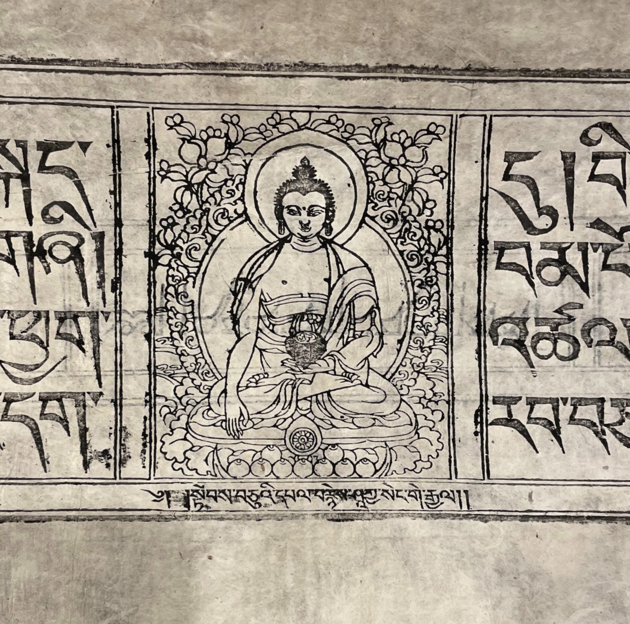 An image of a printed Tibetan text featuring a woodcut of the Buddha.
